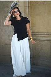 a lady in a black asymmetrical top and a pair of white wide leg pants
